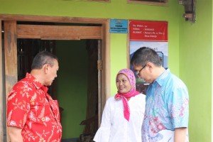 Bupati Kuningan Acep Purnama (kiri) dan Direktur Rumah Swadaya Ditjken Penyediaan Perumahan Kementerian PUPR Johny Fajar Sofyan Subrata (kanan) bersama salah seorang penerima bantuan bedah rumah (tengah) di Kuningan